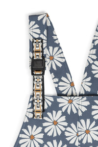 Women's overalls with white daisy pattern on blue background, adjustable shoulder straps visible
