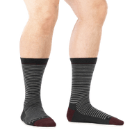 Crew-length striped dress socks with dark charcoal body and burgundy toe and heel, on-model side view