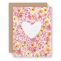 Greeting card with watercolor floral pattern and white heart cutout, shown with brown envelope