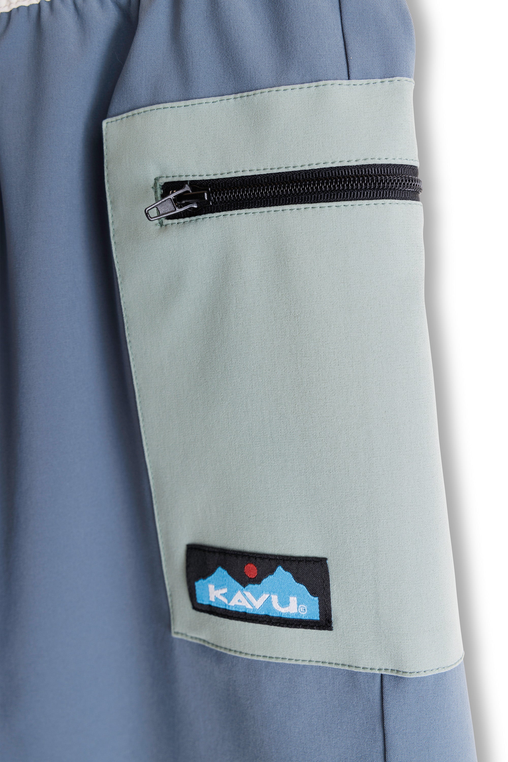 Women's shorts with blue-gray base and light green contrast pocket panel featuring zippered closure