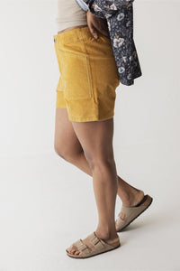 Mustard yellow corduroy shorts with side pockets shown from side angle