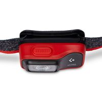 Red and black LED headlamp with adjustable grey strap, front angle view