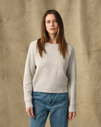 Women's waffle knit crewneck sweater in light cream, front view on model with jeans