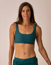 Teal sports bra with scoop neckline and matching high-waisted leggings, front view