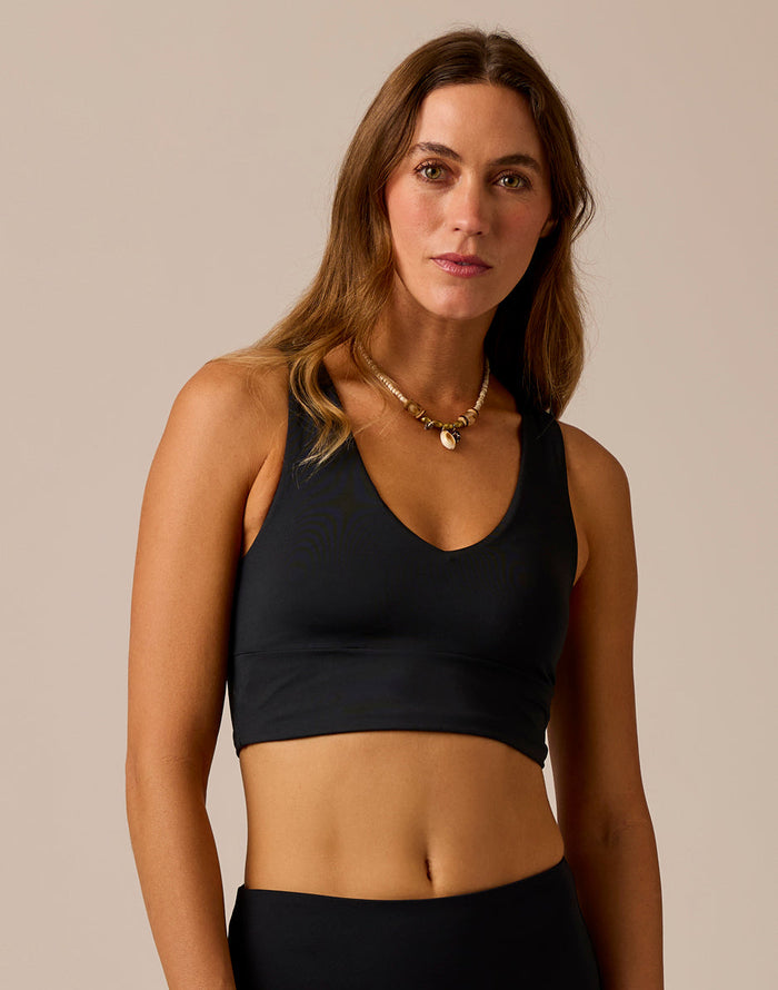 Women's black cropped sports bra top with V-neckline and racerback straps, front view