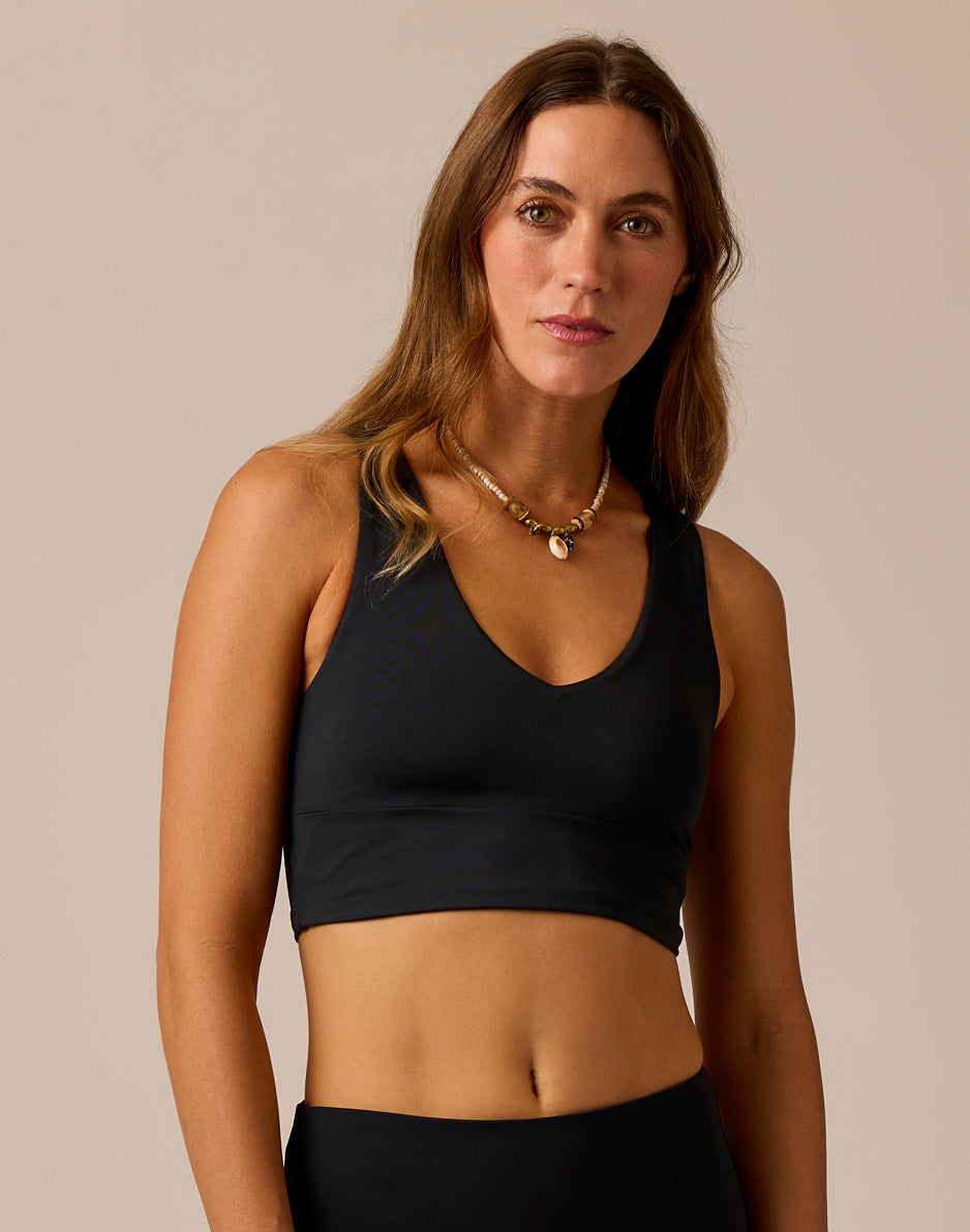 Women's black cropped sports bra top with V-neckline and racerback straps, front view