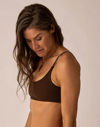 Women's dark brown compression sports bra top with thin straps, front angle view