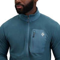 Man wearing teal blue fleece half-zip jacket with chest pocket and brand logo