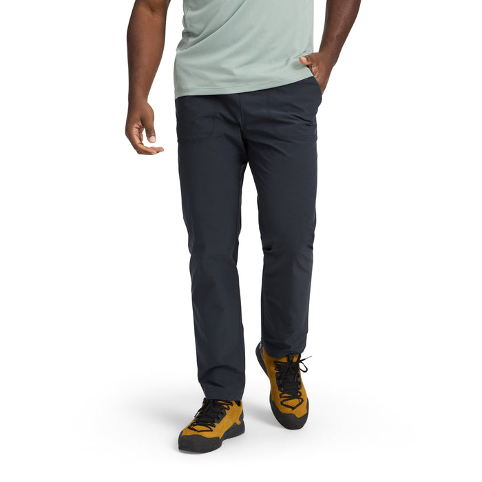 Dark colored men's pants worn with hiking boots in studio setting