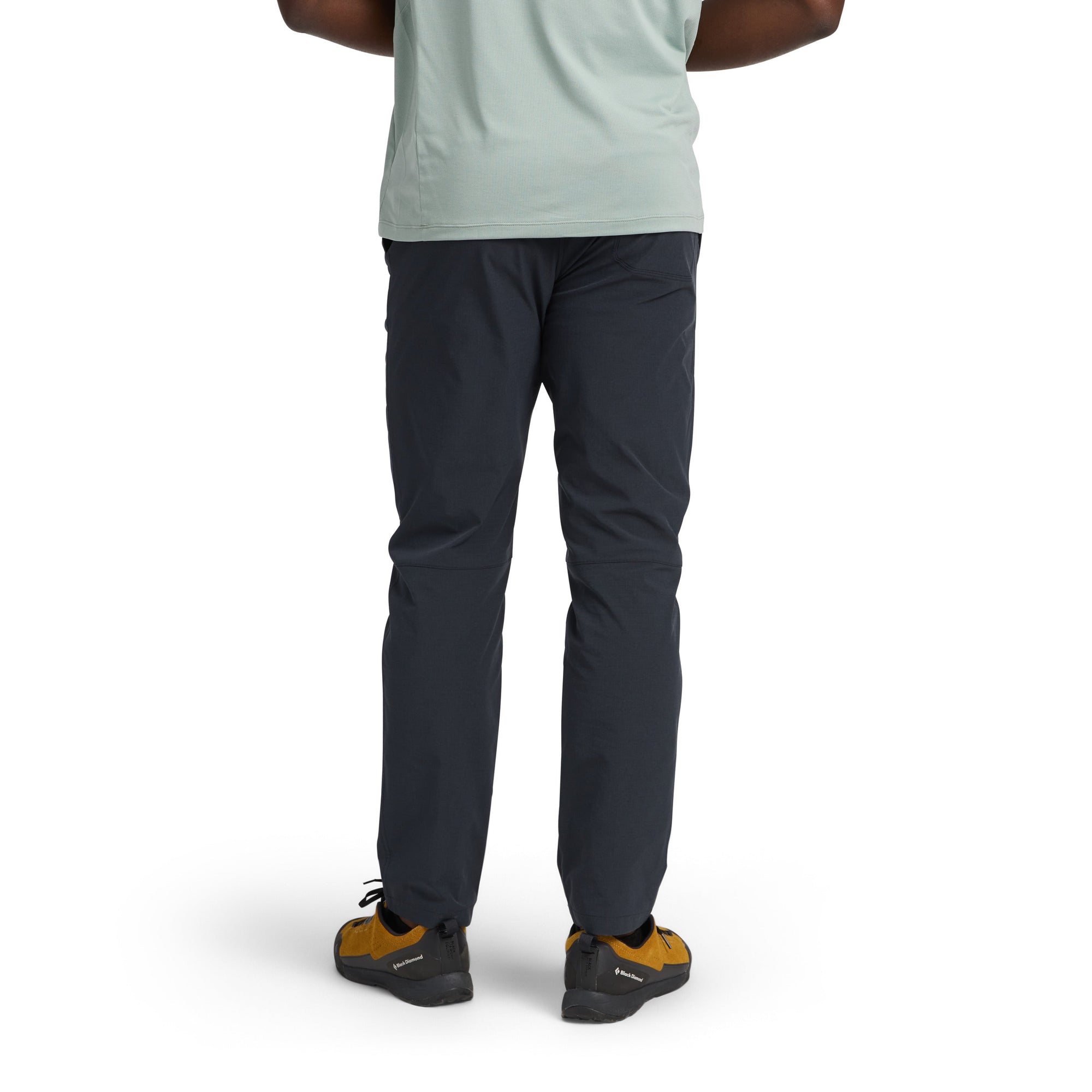 Dark navy blue outdoor pants shown from behind on model with athletic sneakers