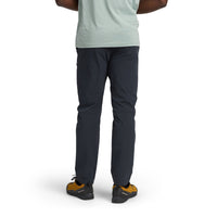 Dark navy blue outdoor pants shown from behind on model with athletic sneakers