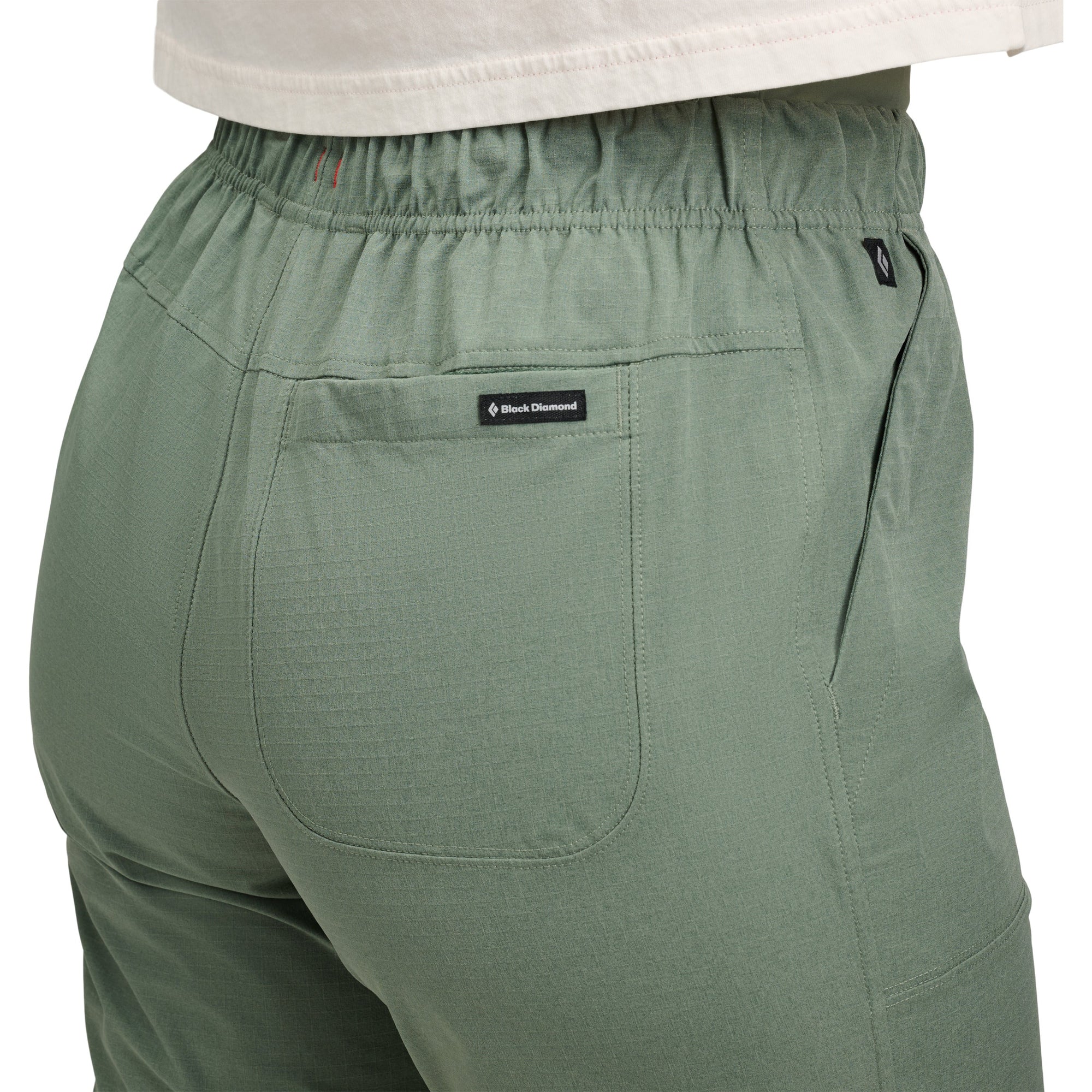 Sage green athletic pants with elastic waistband and back pocket, rear three-quarter view