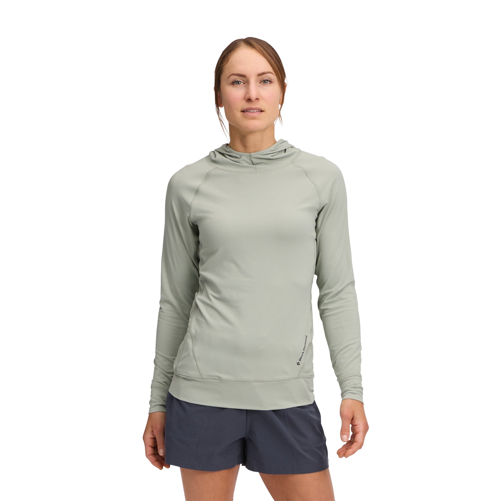 Women's sage green athletic hoodie with long sleeves and hood, worn with navy shorts