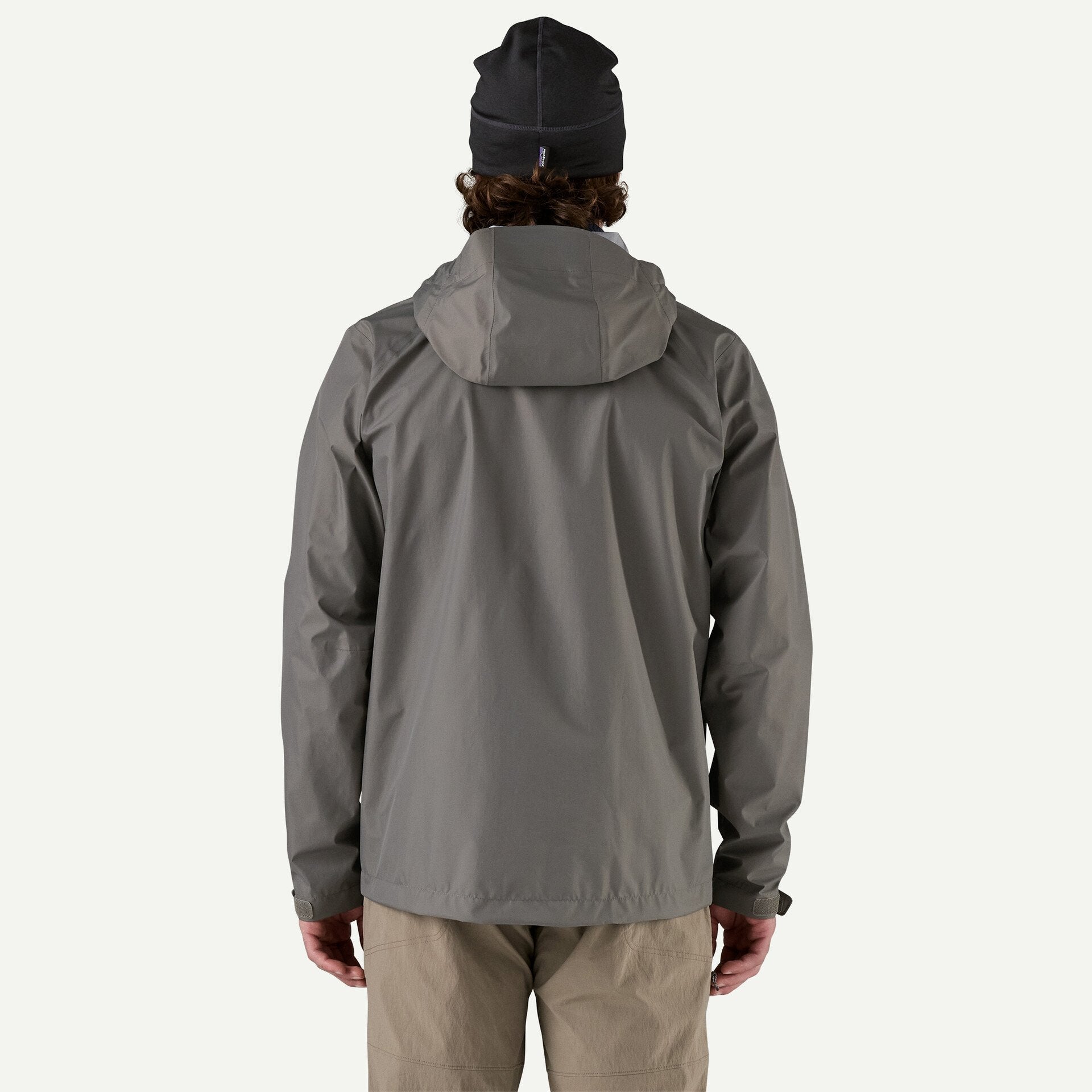 Men's hooded rain jacket in gray, back view, with hood up and khaki pants