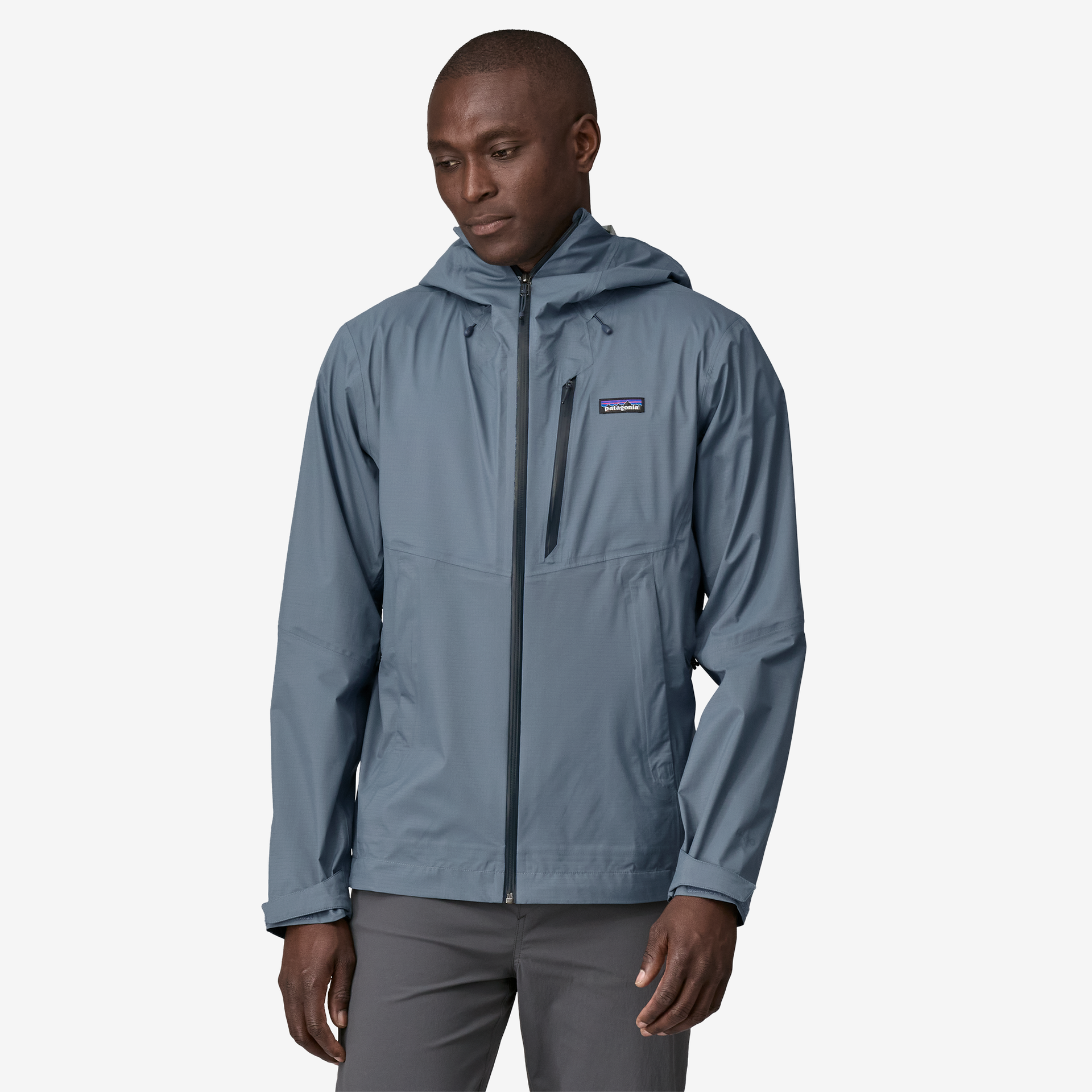 Blue-gray hooded rain jacket with full zip and chest pocket, worn by model