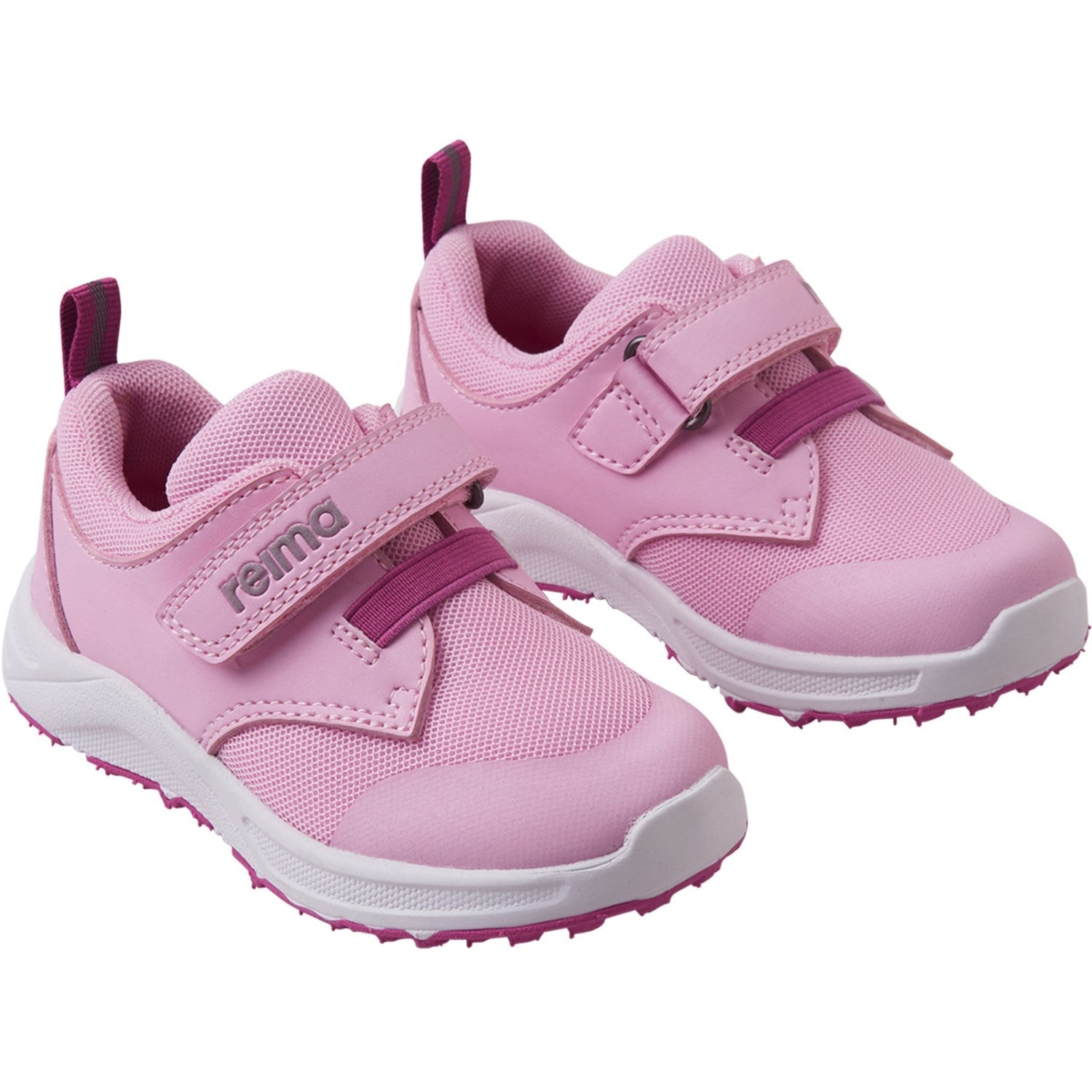 Pink children's athletic sneakers with velcro straps and white soles, angled view