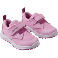 Pink children's athletic sneakers with velcro straps and white soles, angled view