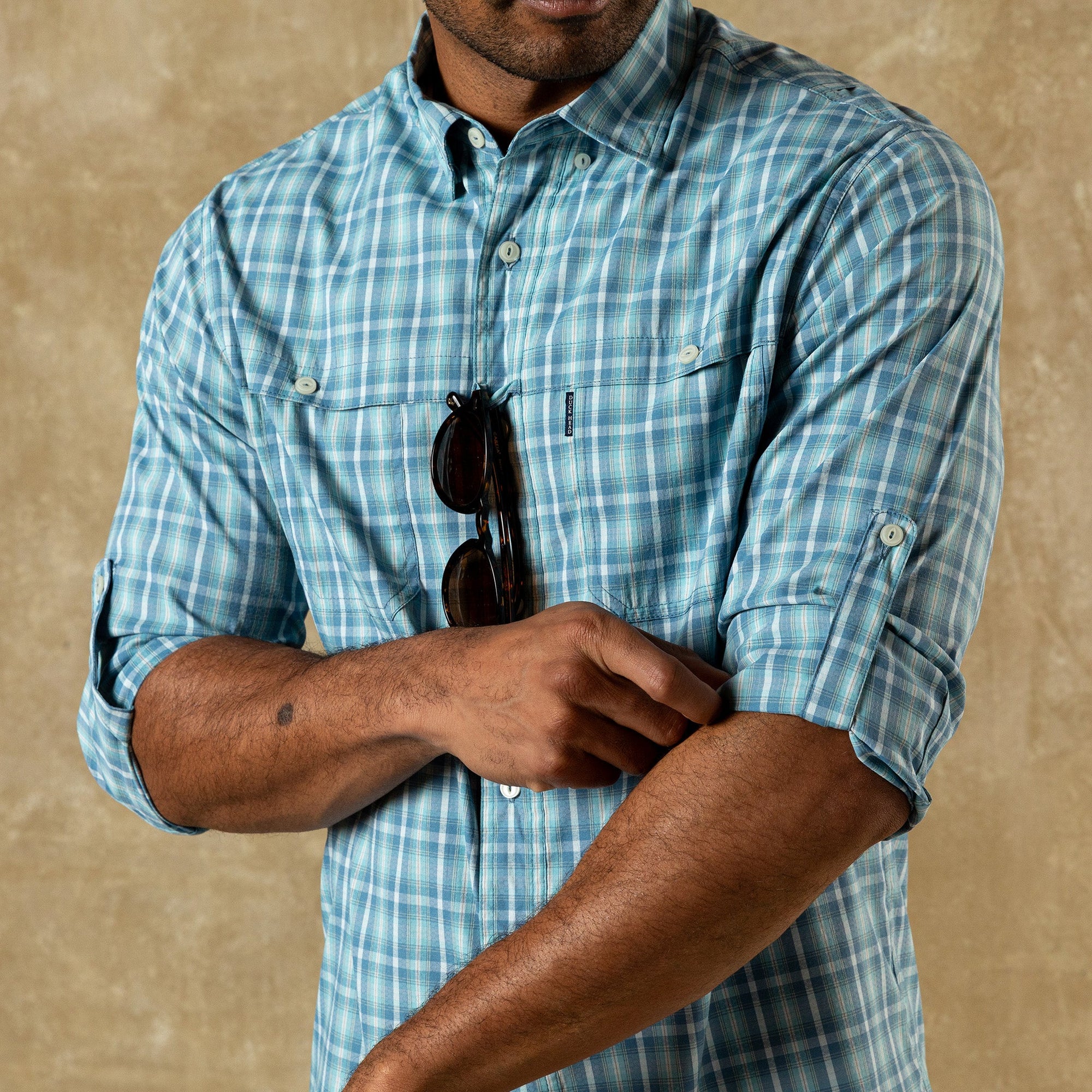 Light blue plaid button-down shirt with rolled sleeves, front view on model