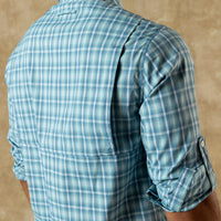 Light blue plaid long sleeve shirt shown from back, sleeves rolled up