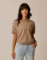 Women's short-sleeve knit sweater tee in warm taupe, front view, paired with light wash jeans