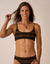 Women's black and gold striped bikini bralette top with thin straps, front view on model