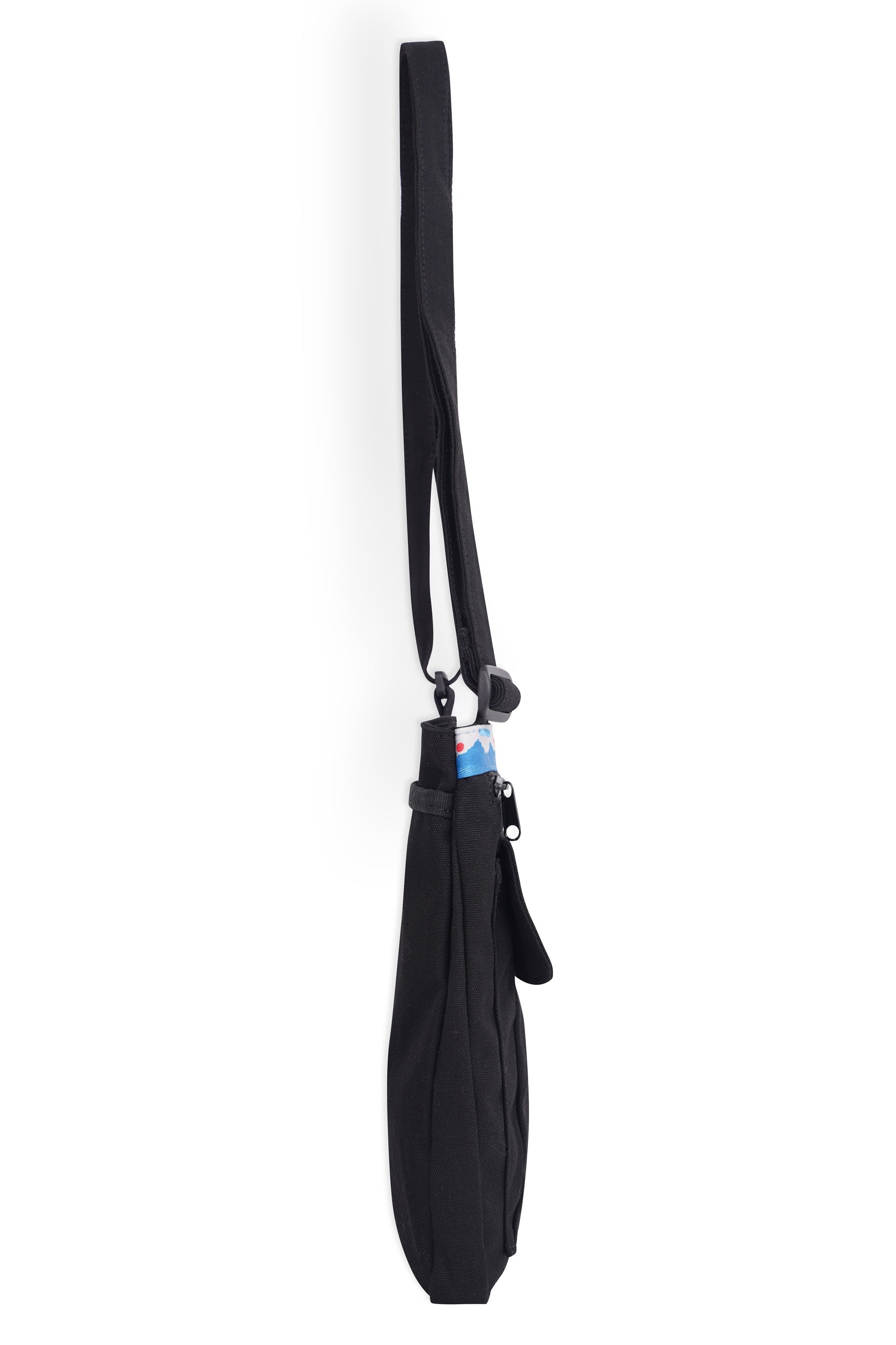 Black crossbody bag with adjustable strap hanging vertically, side profile view