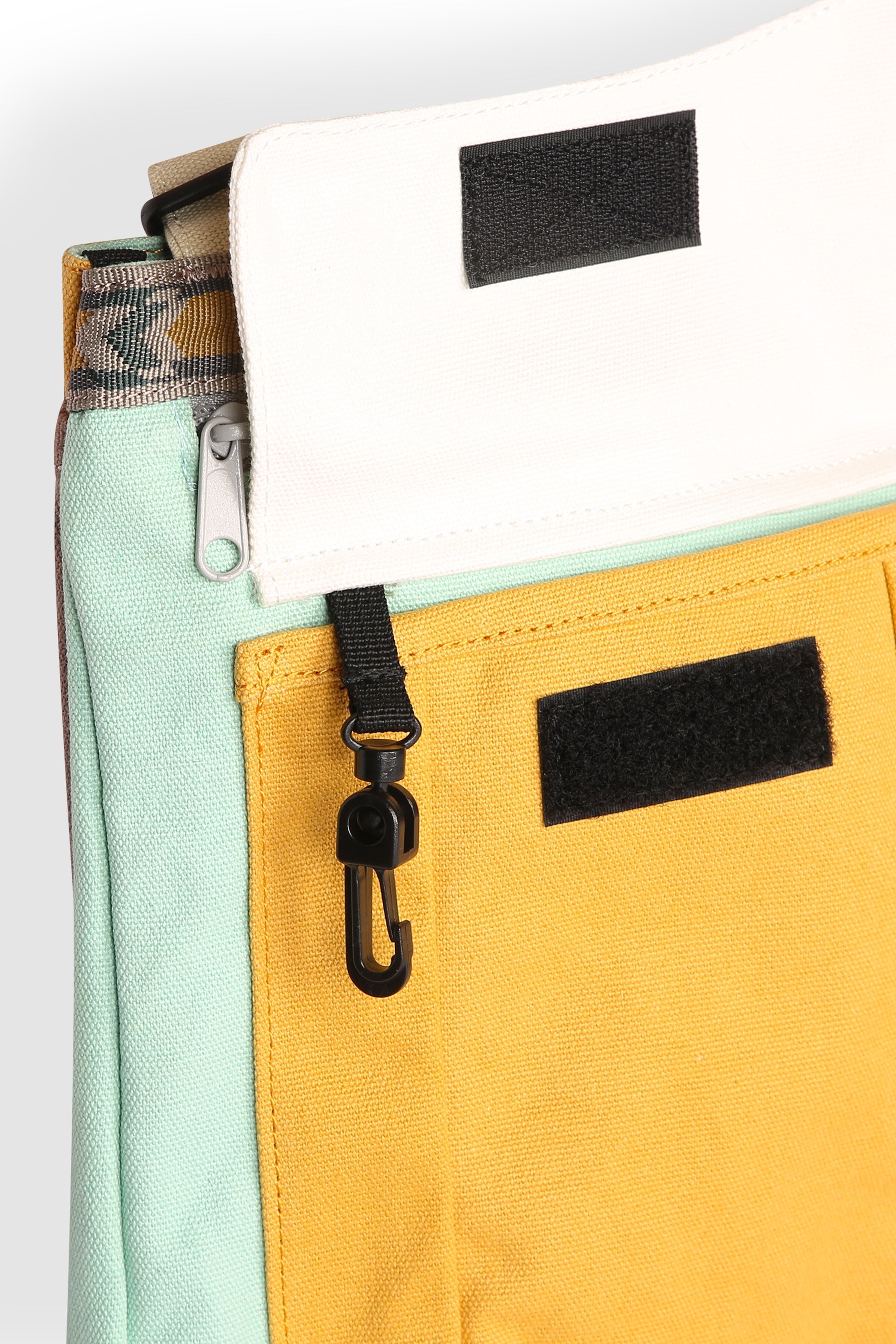 Multi-colored crossbody bag with zippered compartments and adjustable strap, detail view