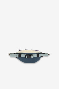 Navy blue waist pack with cream top panel and adjustable side straps, front view