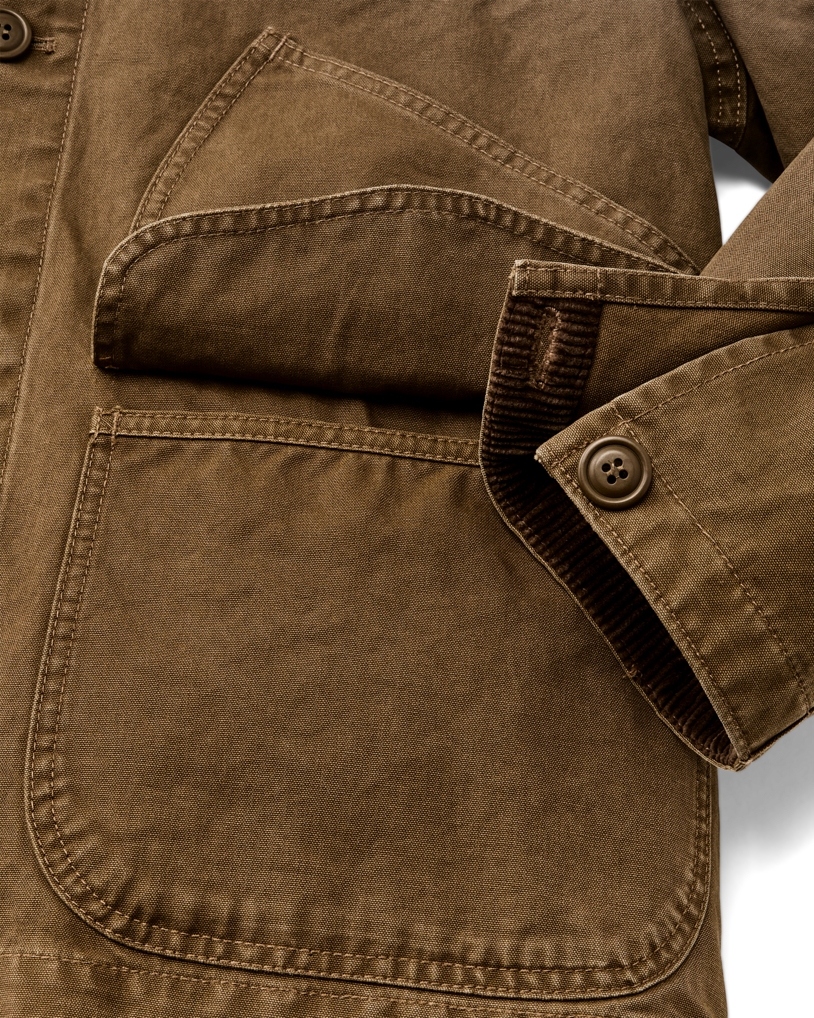 Close-up detail of canvas jacket showing chest pocket, sleeve cuff with corduroy trim and button
