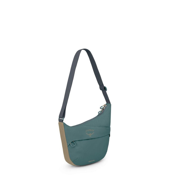 Crescent-shaped crossbody pouch with teal upper, tan lower panel, front zip pocket, and adjustable gray strap