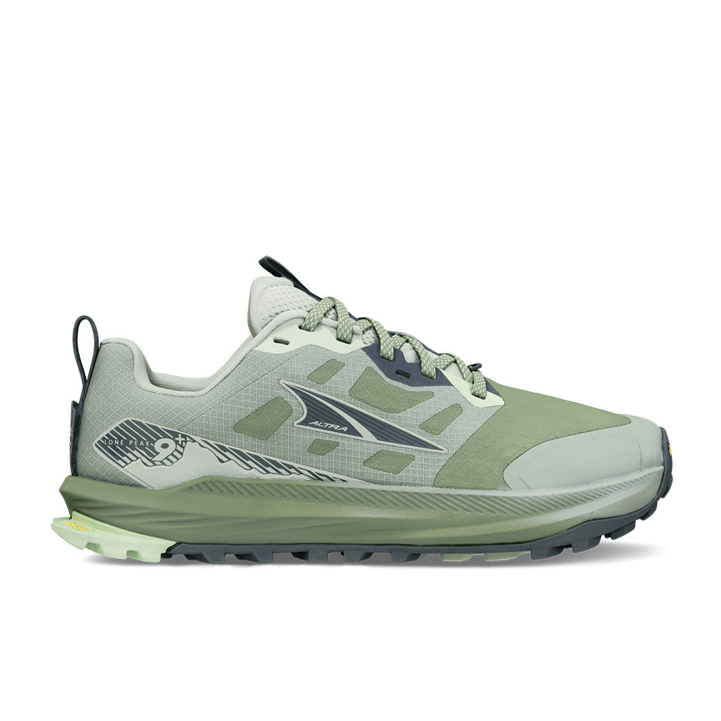 Light green and gray trail running shoe with aggressive outsole lugs, side profile view