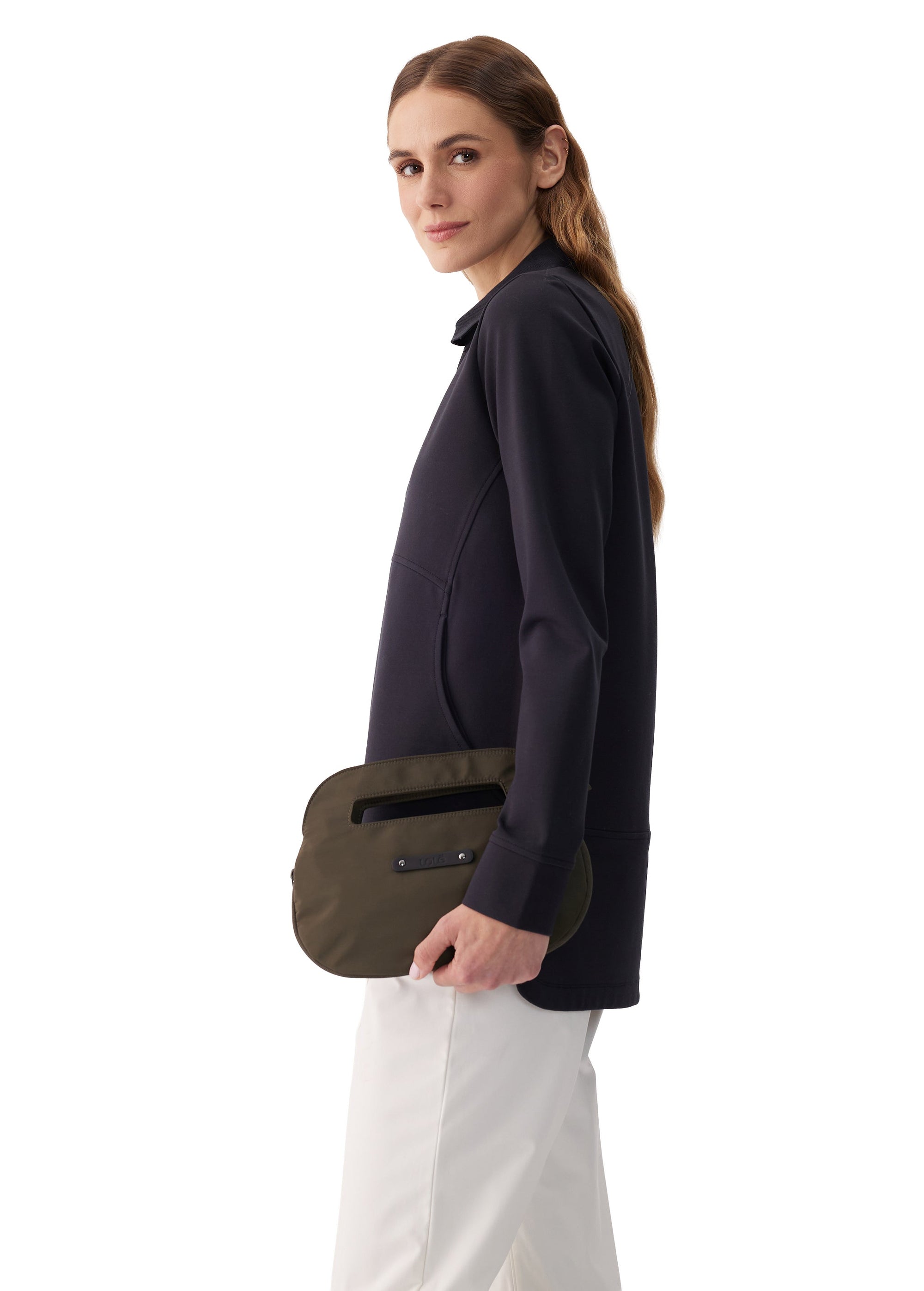 Woman holding an olive green oval-shaped crossbody clutch bag, side view
