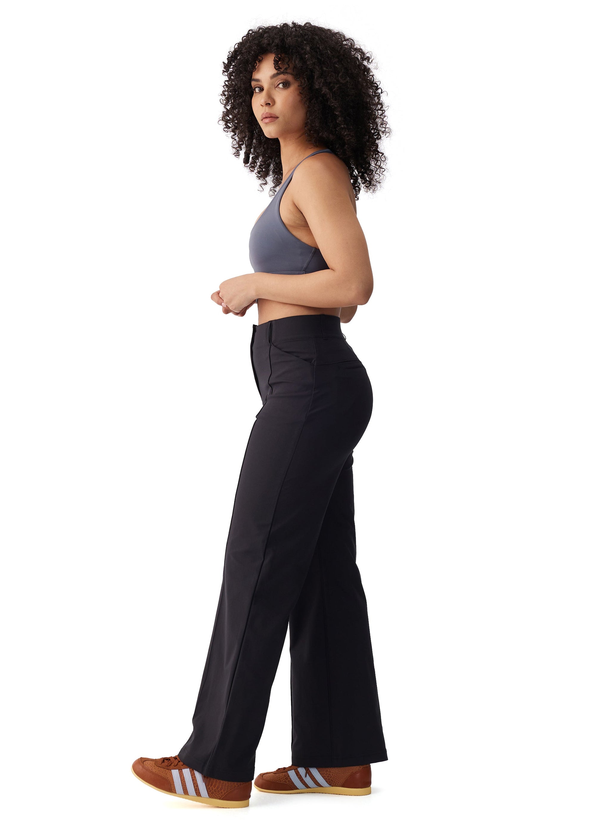 Women's high-waisted wide-leg black travel trousers, side view on model