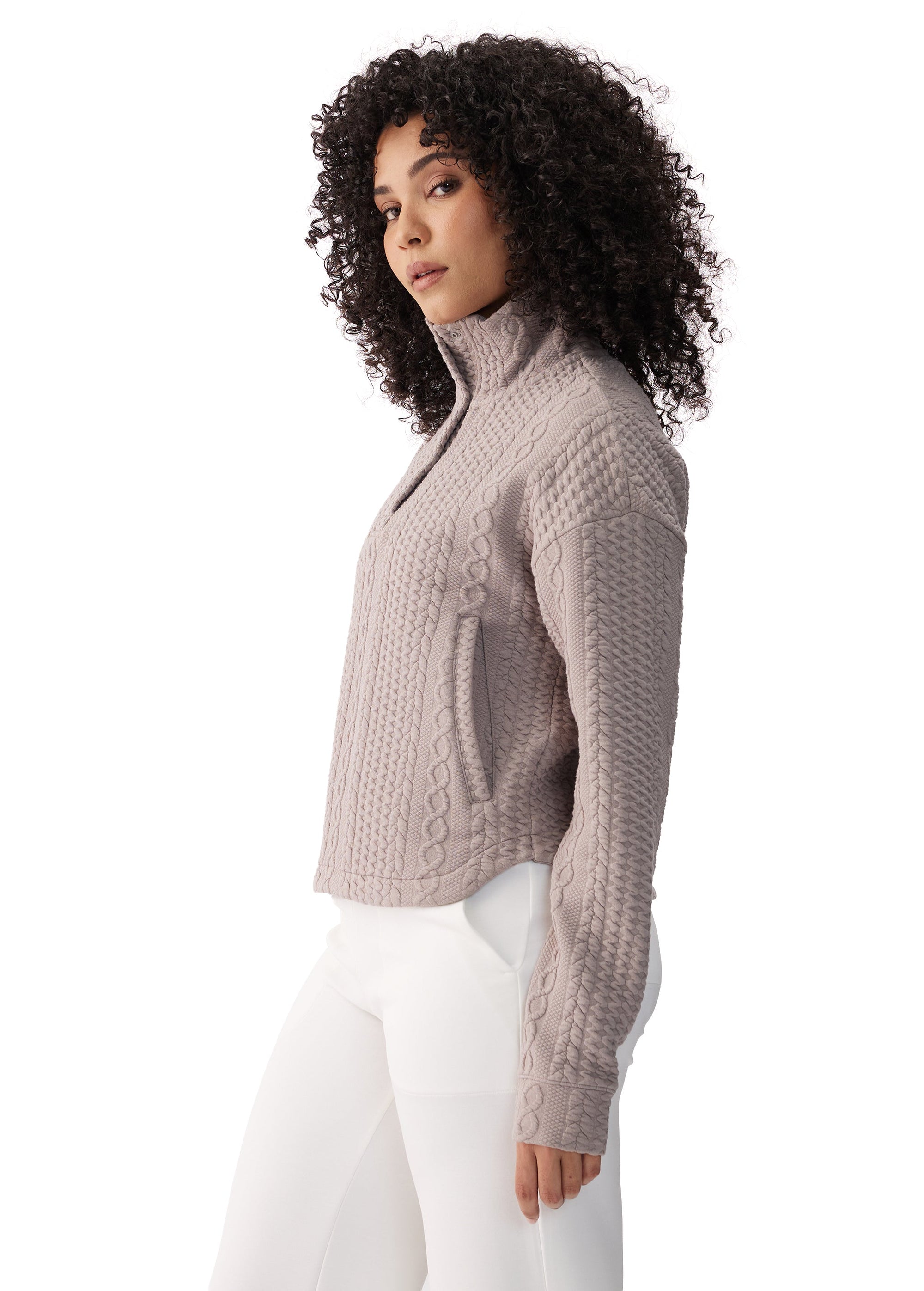 Women's cable-knit zip-up jacket in taupe with mock neck, side view on model