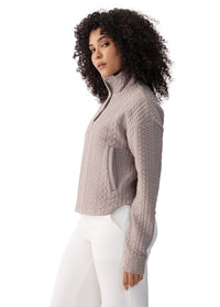 Women's cable-knit zip-up jacket in taupe with mock neck, side view on model