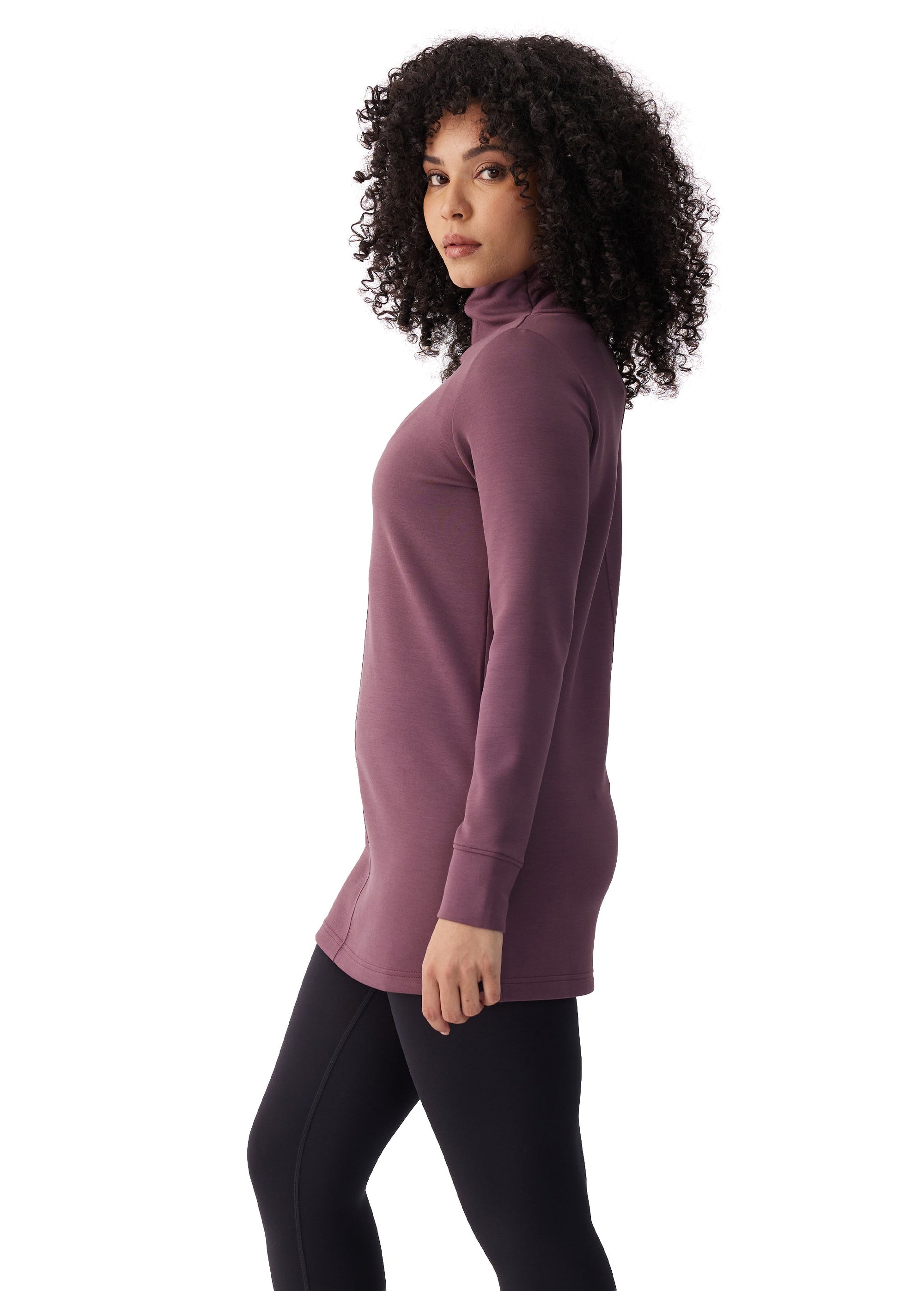 Women's long-sleeve turtleneck tunic top in dusty purple, side view, paired with black leggings