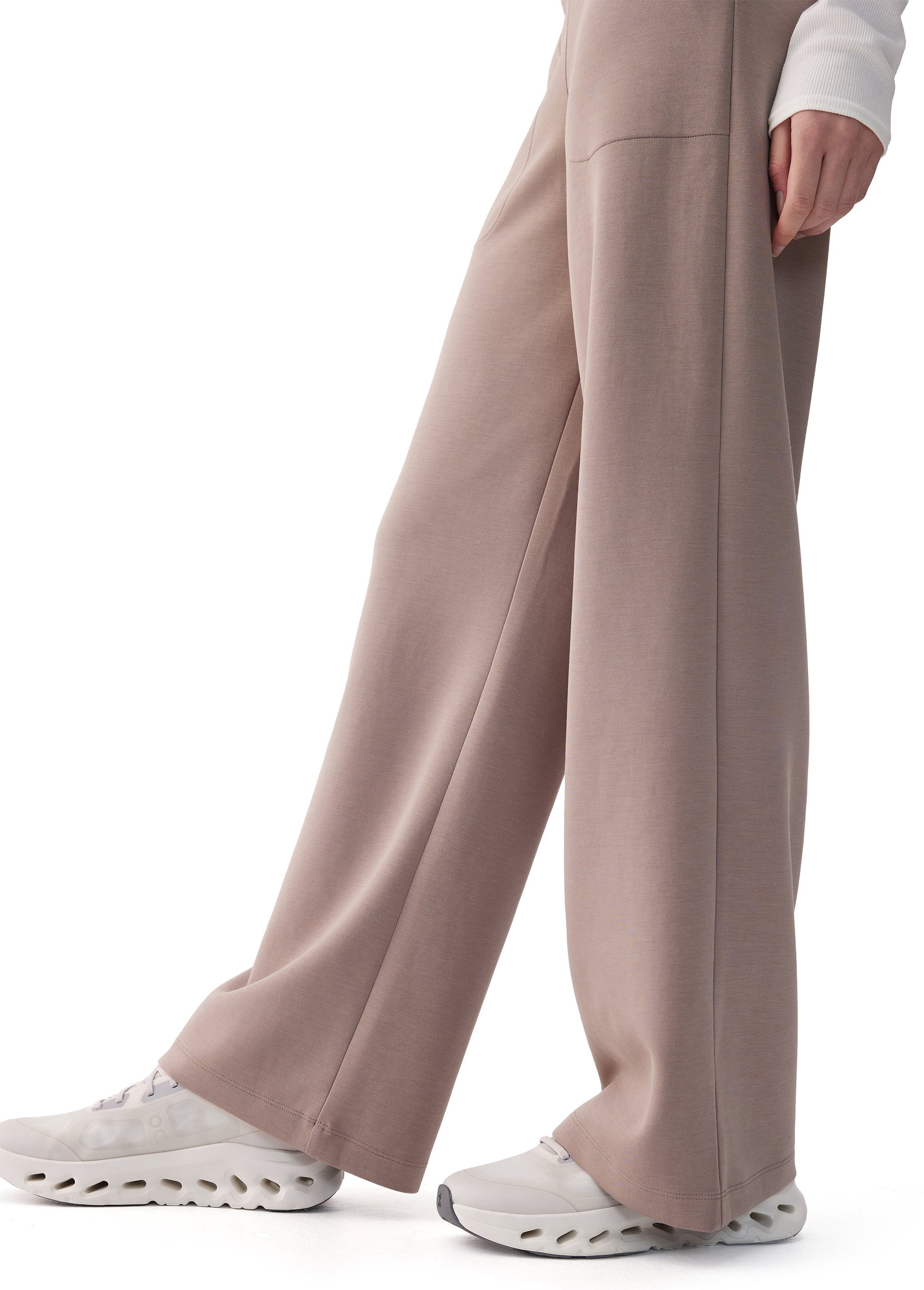 Wide-leg pants in taupe, side view on model, with pressed seam and sneakers