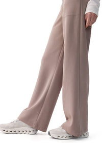 Wide-leg pants in taupe, side view on model, with pressed seam and sneakers