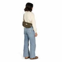 Hip bag in olive green worn crossbody, back view on model in jeans and cream sweater