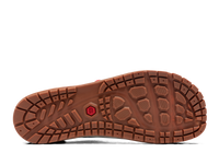 Brown rubber sole of outdoor shoe showing circular tread pattern and grip lugs
