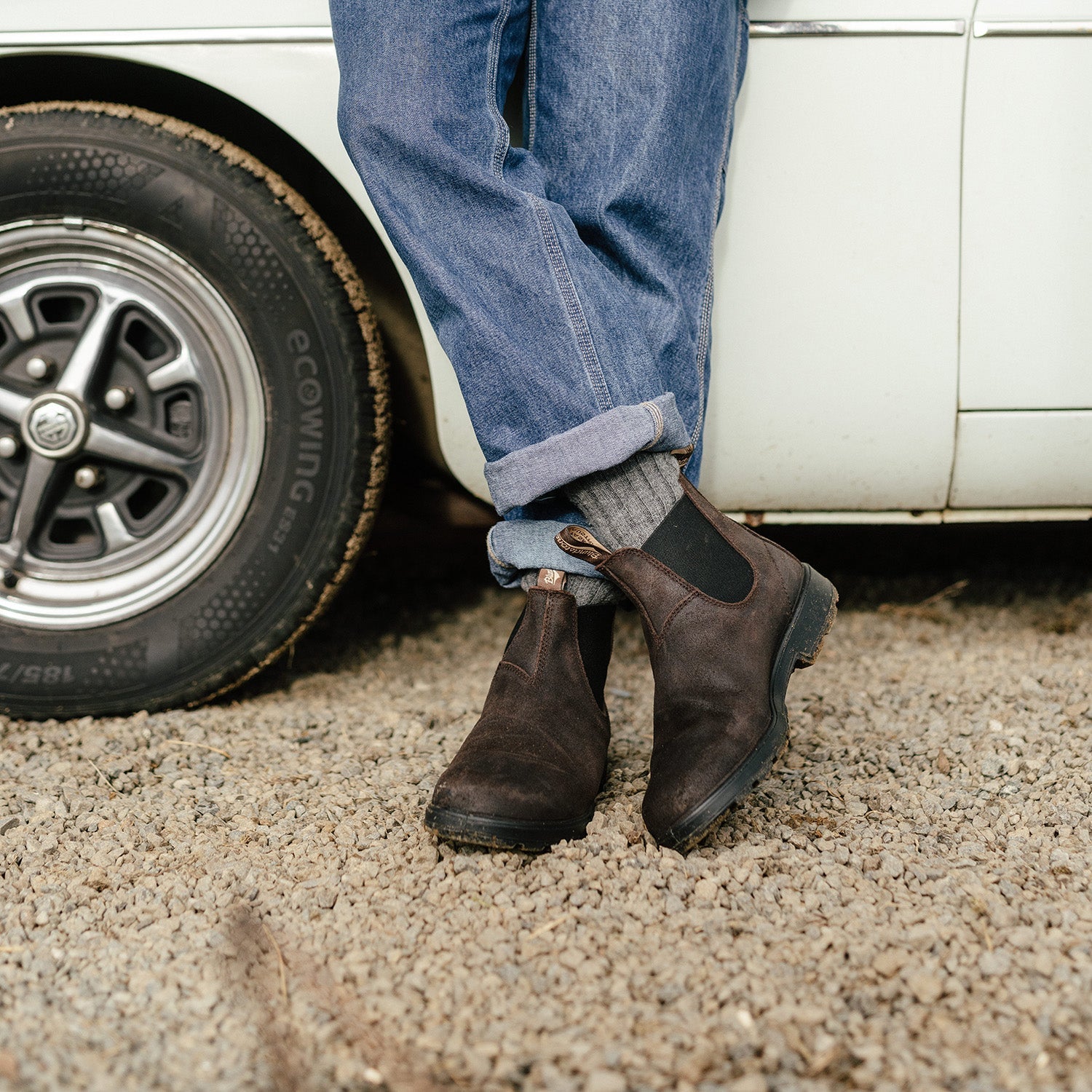 Dark brown suede Chelsea boots with elastic side panels, worn with rolled cuff jeans