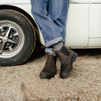 Dark brown suede Chelsea boots with elastic side panels, worn with rolled cuff jeans