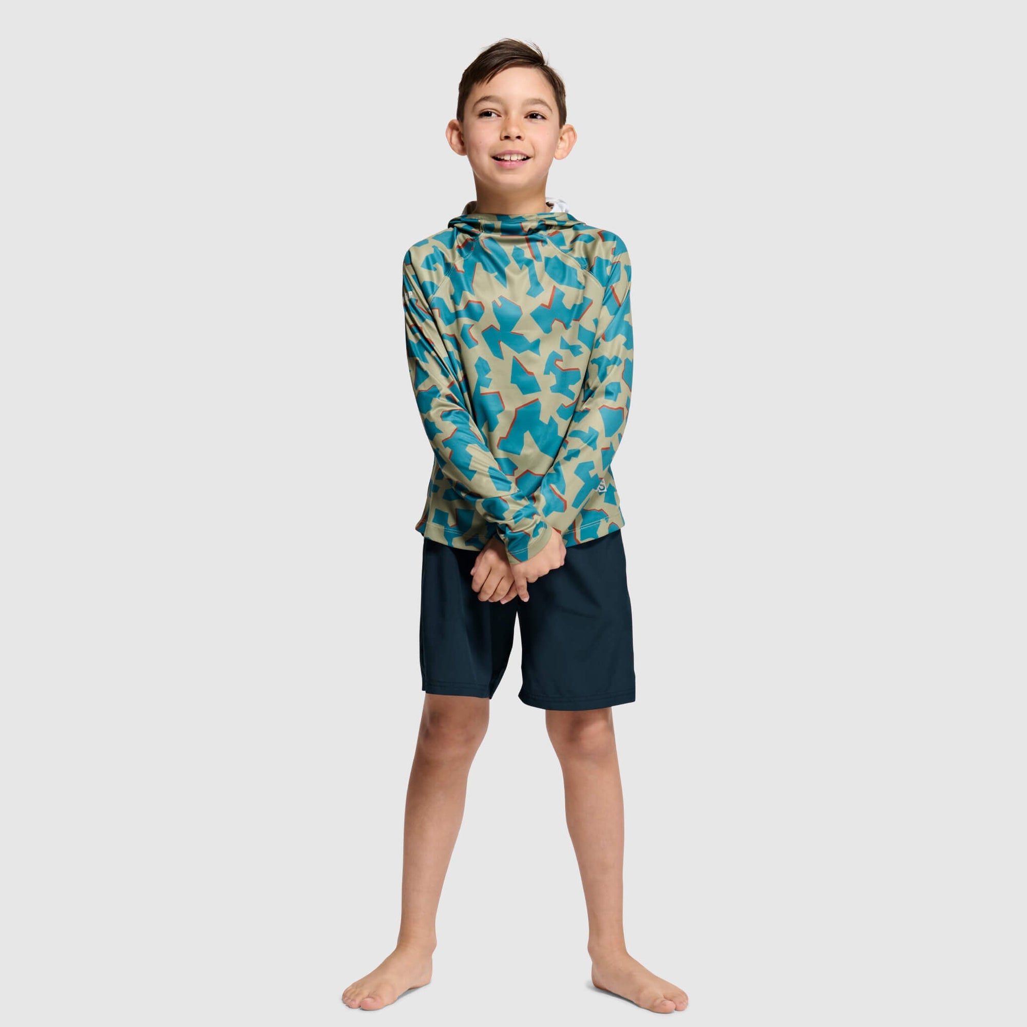 Child wearing geometric camouflage hoodie with matching shorts, full body front view