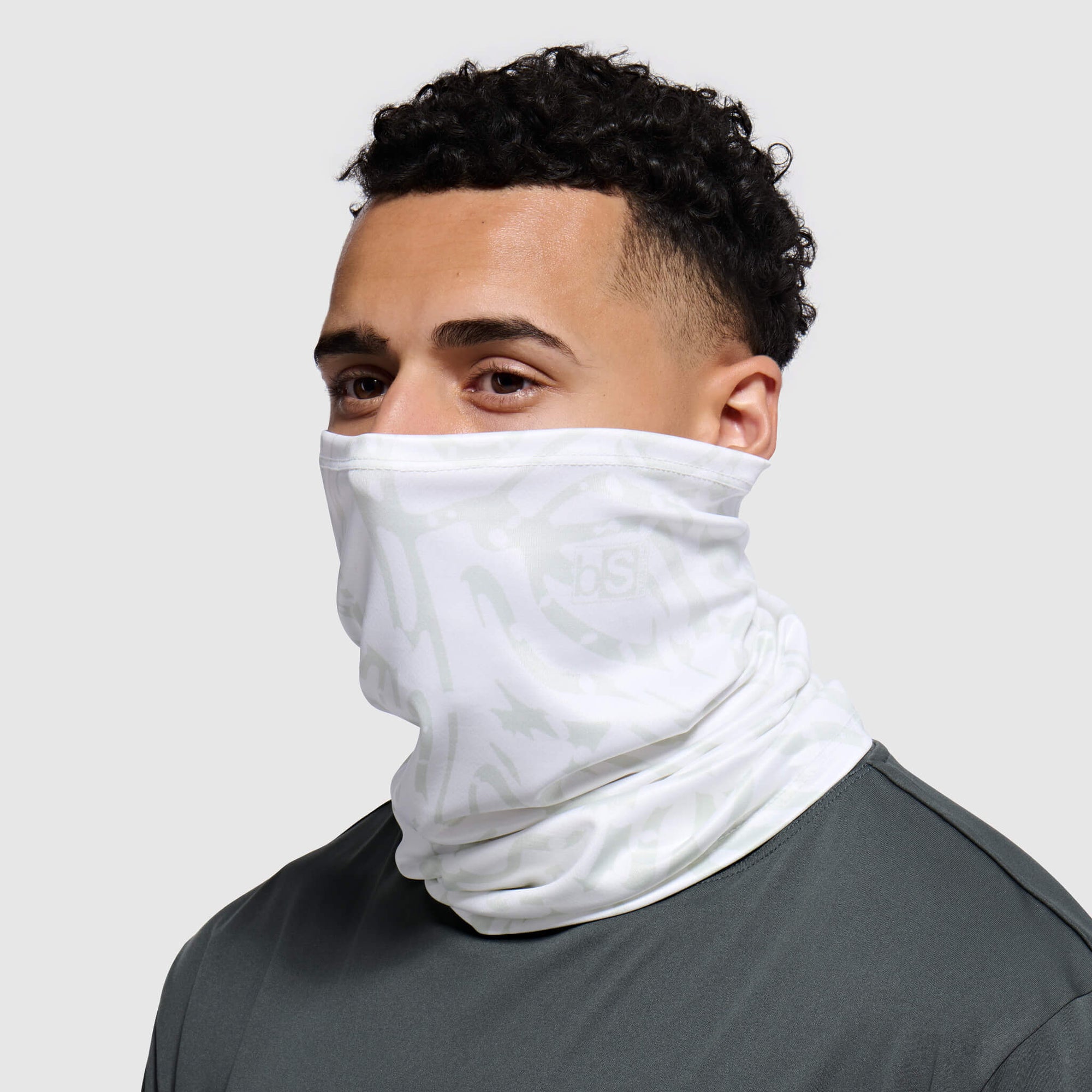 White textured neck gaiter worn by person against neutral background, side angle view