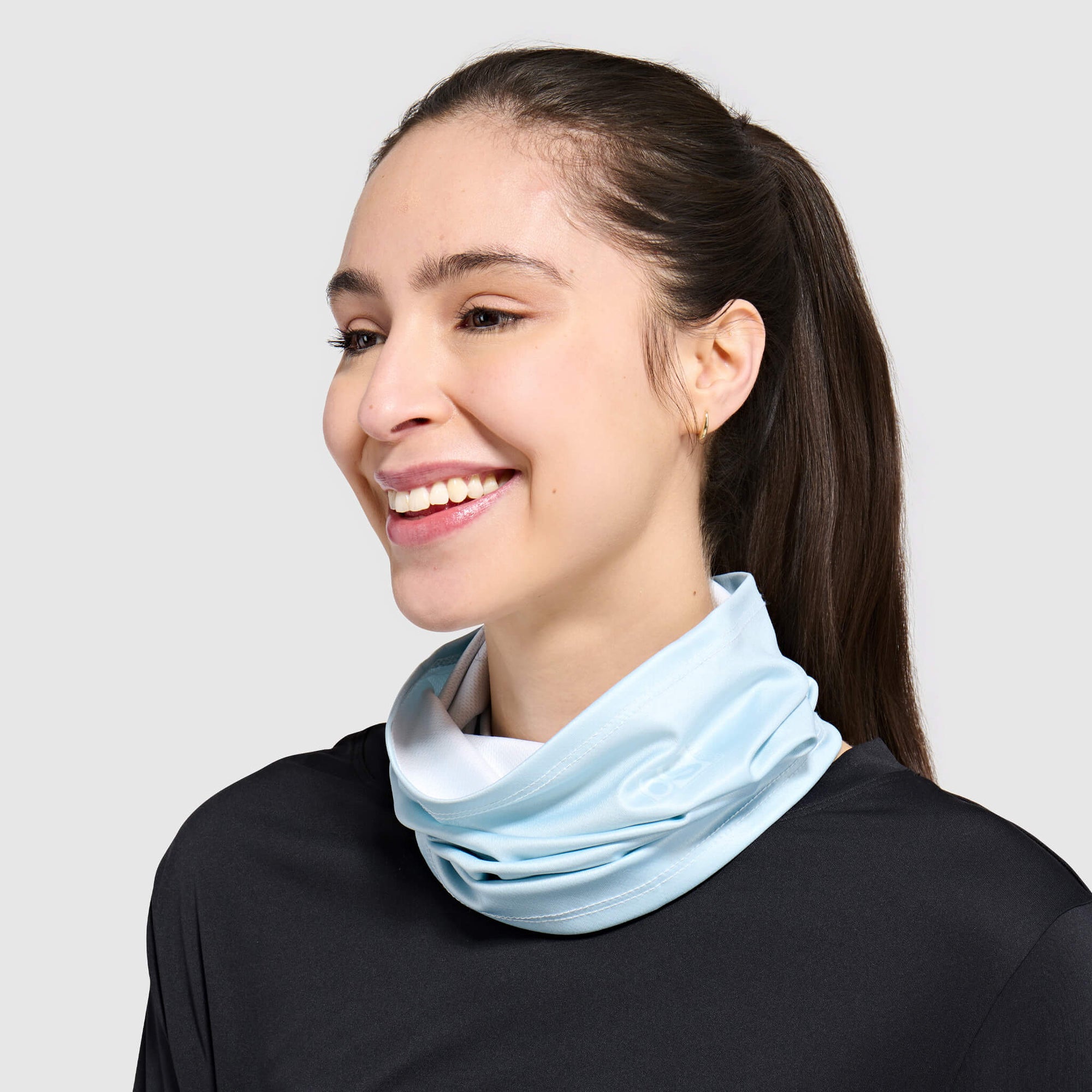 Light blue tube scarf worn around neck over black shirt, side profile view