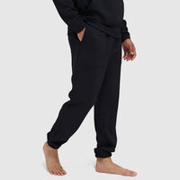 Black textured jogger pants with elastic cuffs and pockets, side view on model