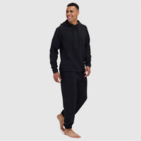 Black jogger sweatsuit with hoodie and matching sweatpants on smiling male model