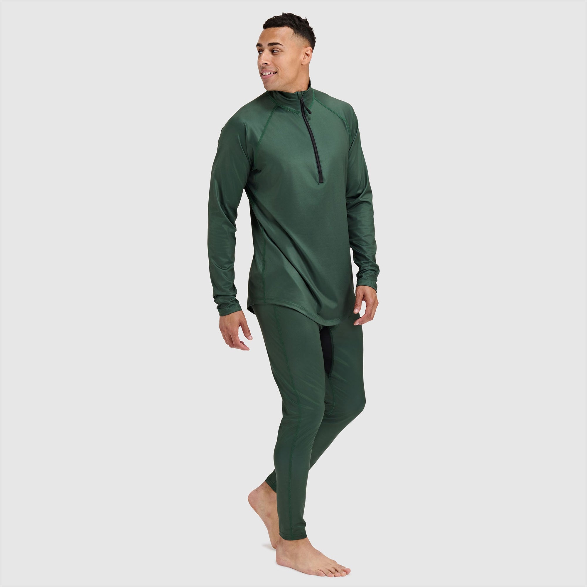 Dark green athletic base layer set with quarter-zip top and matching leggings on male model