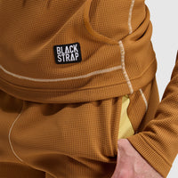 Close-up detail of waffle-knit hoodie showing chest pocket, stitching, and hand in pocket
