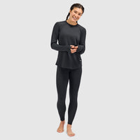 Women's long-sleeve crewneck base layer top with thumbholes, paired with black leggings, front view